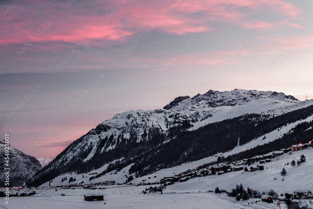 Morning in Livigno, a beautiful sunrise with pink sky near the town in Italy's Morning in Livigno, a beautiful sunrise with pink sky near the town in Italy's