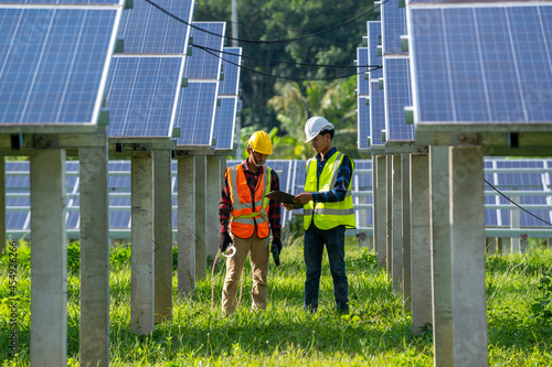 Engineer and electrician inspect solar panel at solar power plant,Engineer working on replacement solar panel. photo