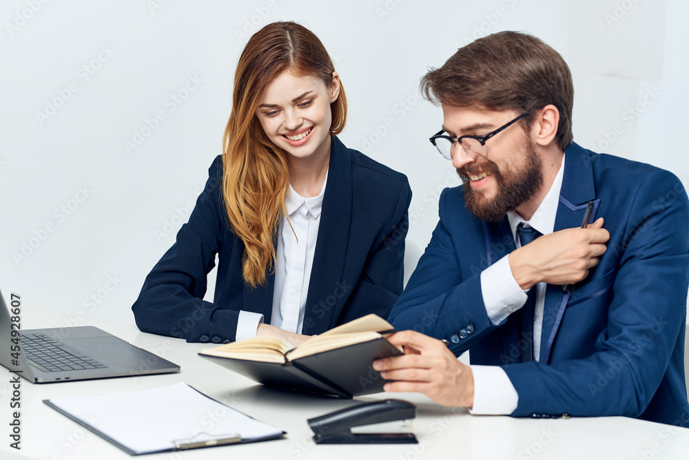man and woman managers sitting at the table in front of laptop team technology man and woman managers sitting at the table in front of laptop team technology