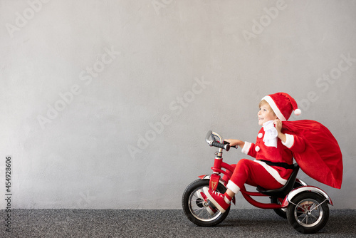 Happy child riding bike. Christmas holiday concept