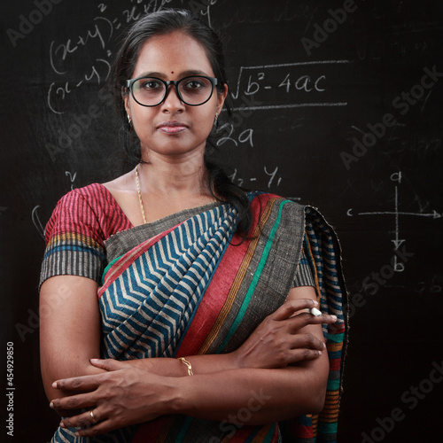 Photography Portrait of Indian ethnic  lady teacher stands in front of a blackboard