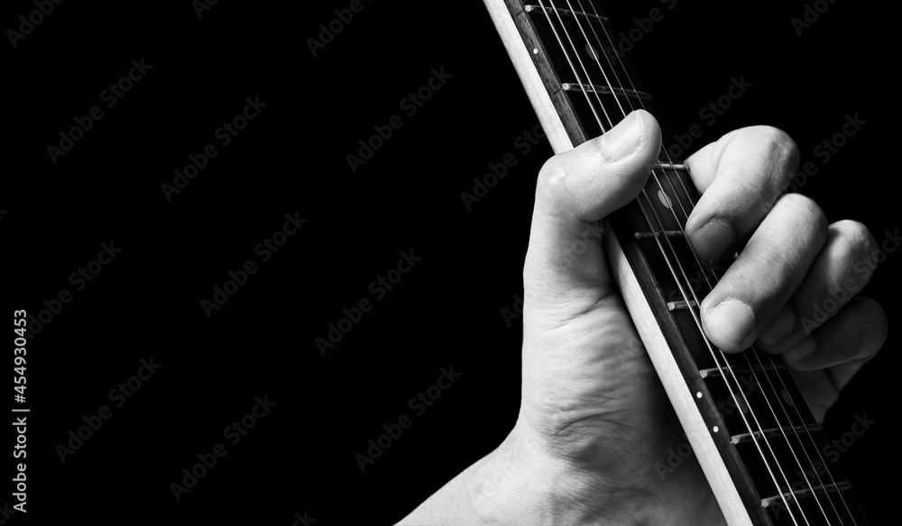 close up male musician left hand playing chord on electric guitar neck. music background close up male musician left hand playing chord on electric guitar neck. music background