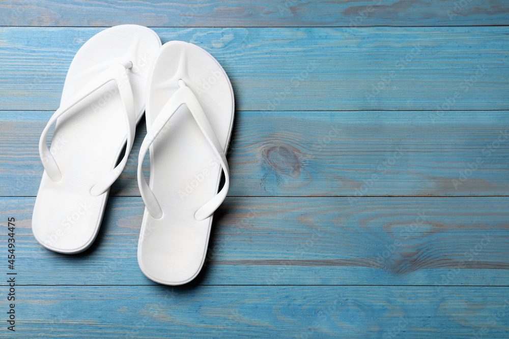 Stylish beach flip flops on blue wooden background, flat lay. Space for text Stylish beach flip flops on blue wooden background, flat lay. Space for text
