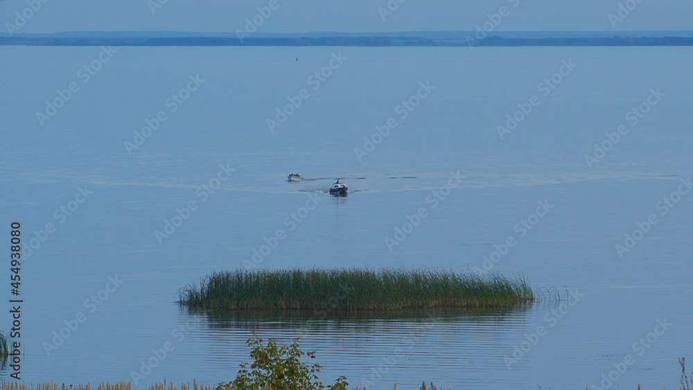 Two boats sails to the shore, evening at the mouth of the Kama River, which flows into the Volga River, Republic of Tatarstan, Russia. Two boats sails to the shore, evening at the mouth of the Kama River, which flows into the Volga River, Republic of Tatarstan, Russia.
