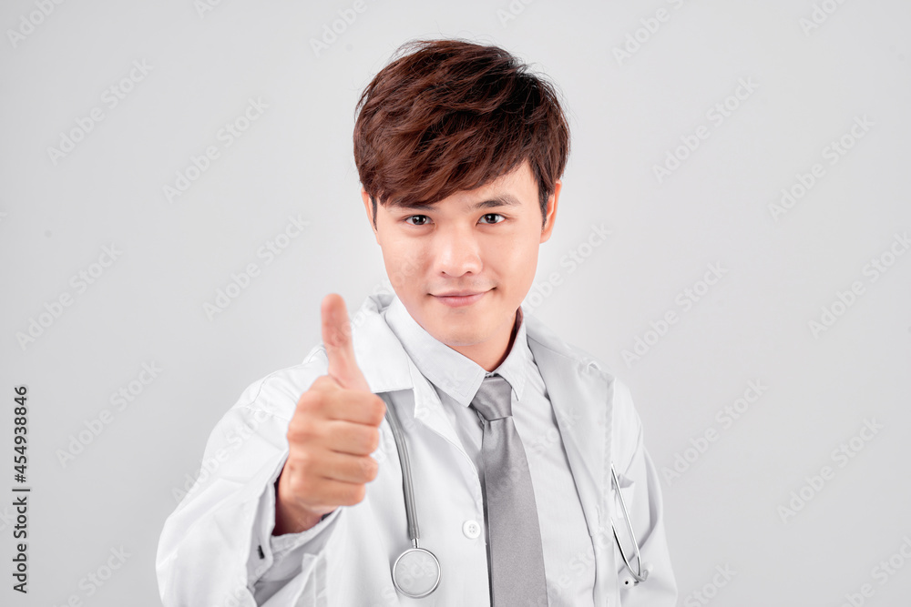 Positive asian male doctor in lab coat showing thumb up gesture over white background Positive asian male doctor in lab coat showing thumb up gesture over white background
