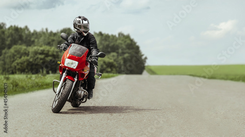 Biker rides a motorcycle and prepares to turn © uladzislaulineu