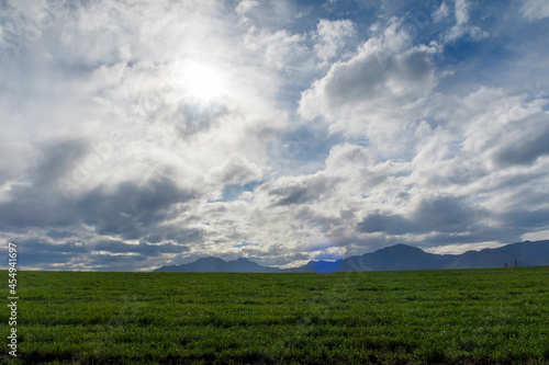 Dramatic skyline background of colored cloud against a distant field and horizon