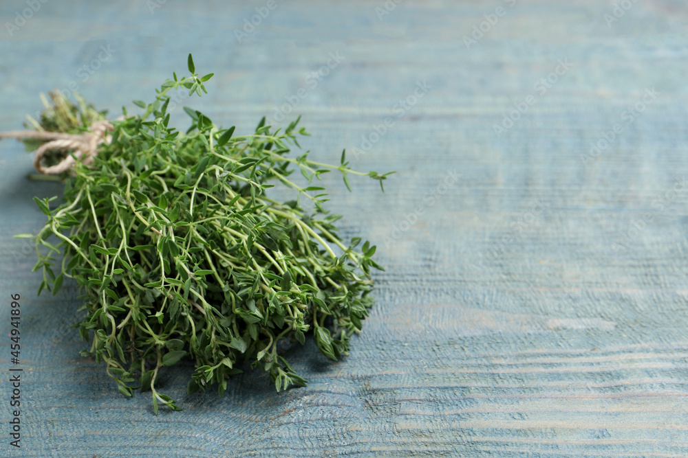 Bunch of aromatic thyme on light blue wooden table, closeup. Space for text Bunch of aromatic thyme on light blue wooden table, closeup. Space for text