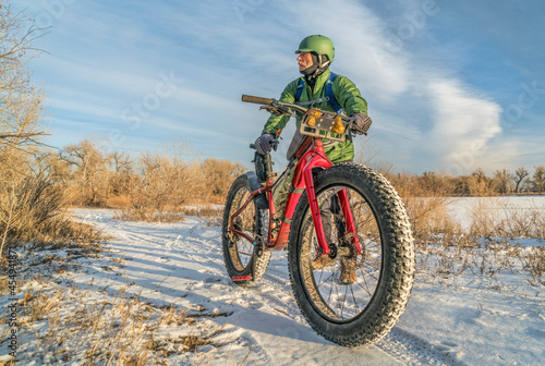 senior cyclist with a fat mountain bike in winter, cold day in Colorado photo