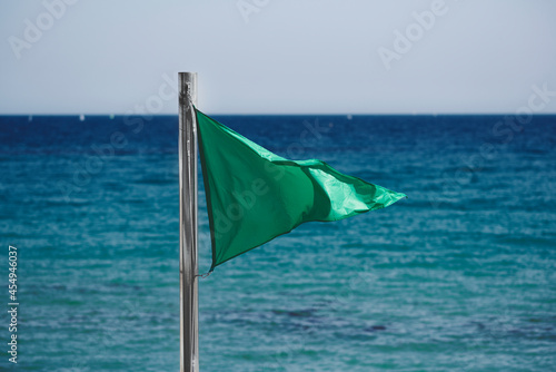 green flag on the beach at summer. barcelona