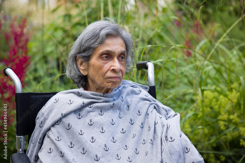 Old Indian woman in a wheelchair. UK elderly mental health