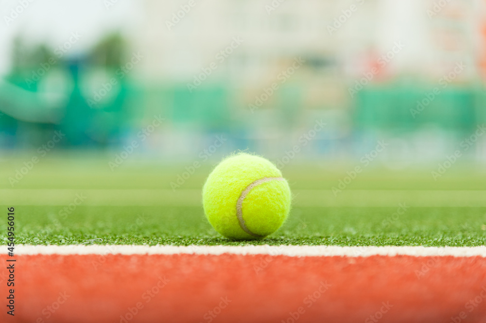 Tennis ball on a green tennis court. Photo with soft focus.