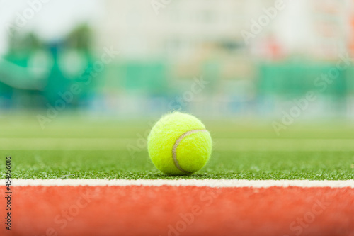 Tennis ball on a green tennis court. Photo with soft focus. © yallowww