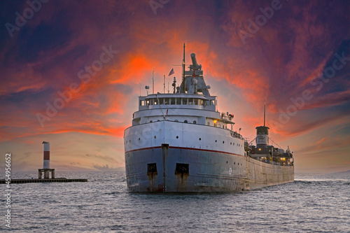 Large freighter entering a Holland Michigan harbor at sunset time photo