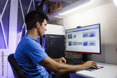 Fotografie Young man selecting a 3D design before printing in his 3D printer
