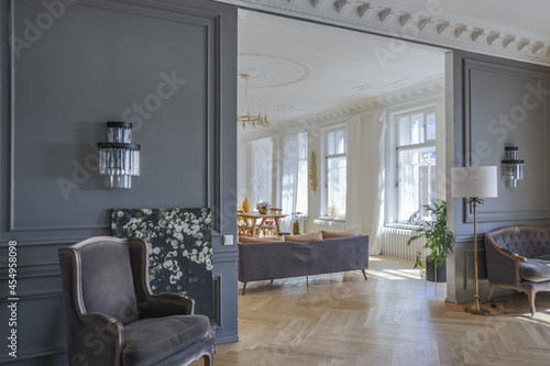 luxury interior of a spacious apartment in an old 19th century historical house with modern furniture. high ceiling and walls are decorated with stucco