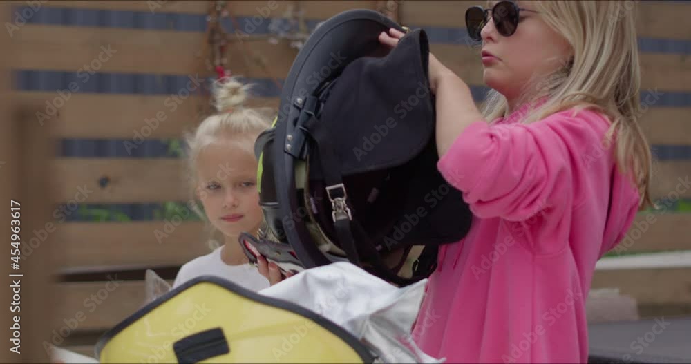 two girls put on firefighter helmets two girls put on firefighter helmets