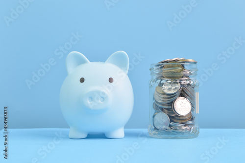 Front view of piggy bank and coins. Retirement, save money and investing concept