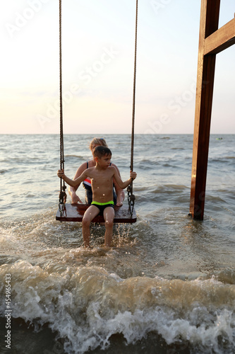Woman rocks boy on swing in Sea of Azov