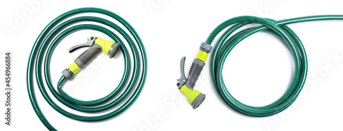 Green rubber watering hoses on white background, top view. Banner design photo