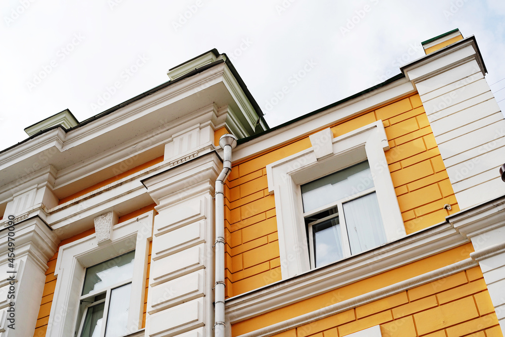 Fragment of an old house with a beautiful facade and stucco molding. Close-up