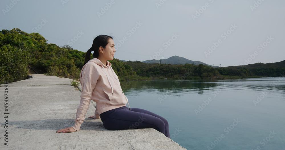 Woman sit at the pier and enjoy the sea view
