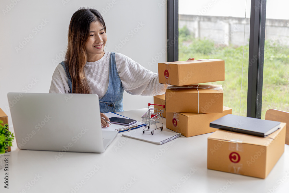 An online seller is counting the number of parcel boxes in preparation for shipping to customers, brown parcel boxes tied with ropes to avoid damage. Online shopping concept. An online seller is counting the number of parcel boxes in preparation for shipping to customers, brown parcel boxes tied with ropes to avoid damage. Online shopping concept.
