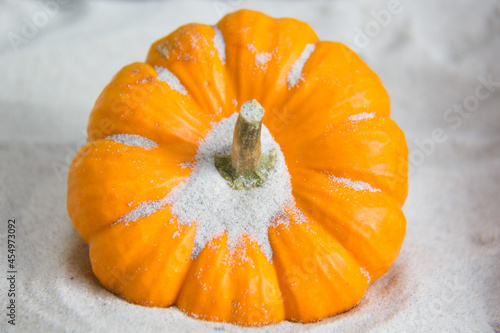 Orange pumpkin on white sand