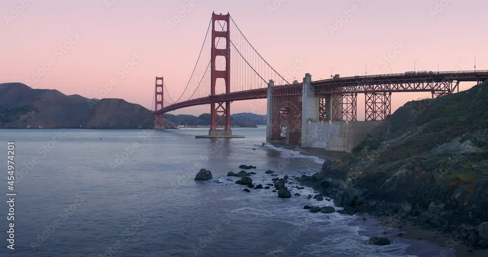 Aerial: Golden Gate Bridge and waves crashing on Marshall Beach at sunrise. San Francisco, USA Aerial: Golden Gate Bridge and waves crashing on Marshall Beach at sunrise. San Francisco, USA