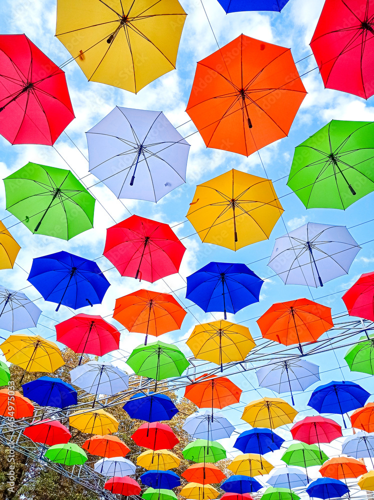 Autumn-themed umbrellas hang over the park alley