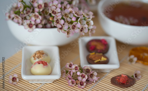 A cup of tea and sweets on the table with flowers