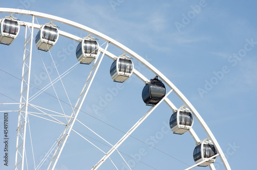 Closeup of gondola of a ferry wheel with a clear blue sky