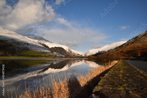 the still waters of tal-y-llyn lake with the snow covered welsh mountain tops reflected in its waters