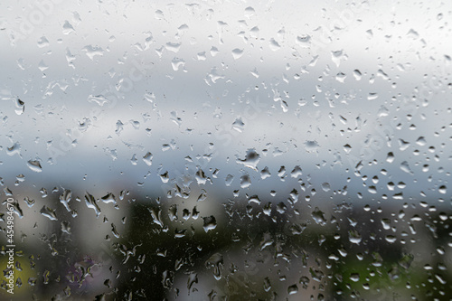 raindrops on window glass, selective focus, rainy city background, wet glass, texture of raindrops