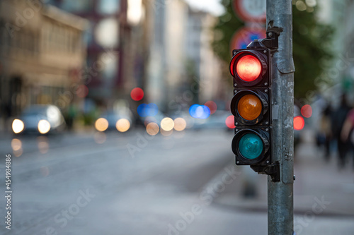 view of city traffic with traffic lights, in the foreground a traffic light with a red light