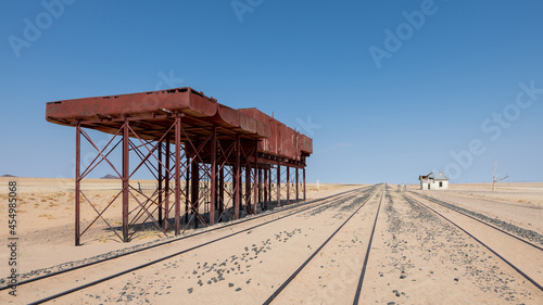 Fototapeta Naklejka Na Ścianę i Meble -  Former, crumbled train station with water tank in a lonely area near the desert horses at Garub, Namibia, Africa.