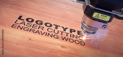 Laser cutter close up, engraved logo on a wooden board.  photo