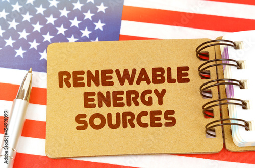 On the US flag lies a notebook with the inscription - renewable energy sources