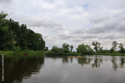 Nice summer lake a cloudy day outside in the Swedish nature. Calm dark water, small wooden bridge or jetty. Västergötland, Sweden, Europe.