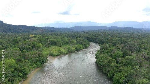 Aerial view over a large tropical river with an open patch at one side photo