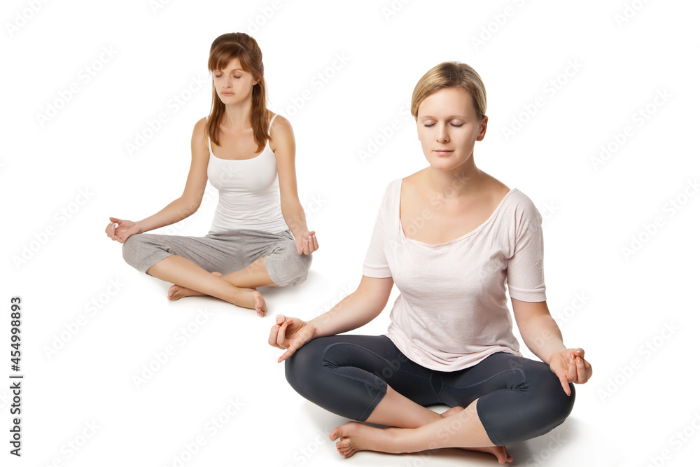 Group of people relaxing and doing yoga in white
