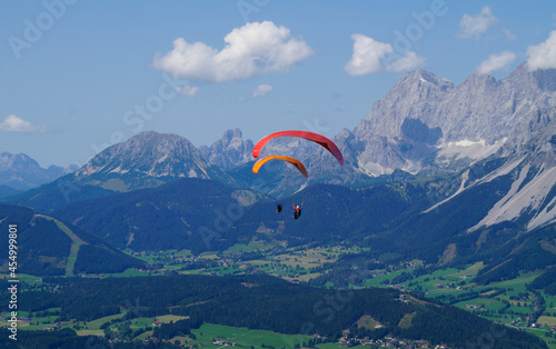 two friends paragliding in the Austrian Alps of the Schladming-Dachstein region (Austria) 