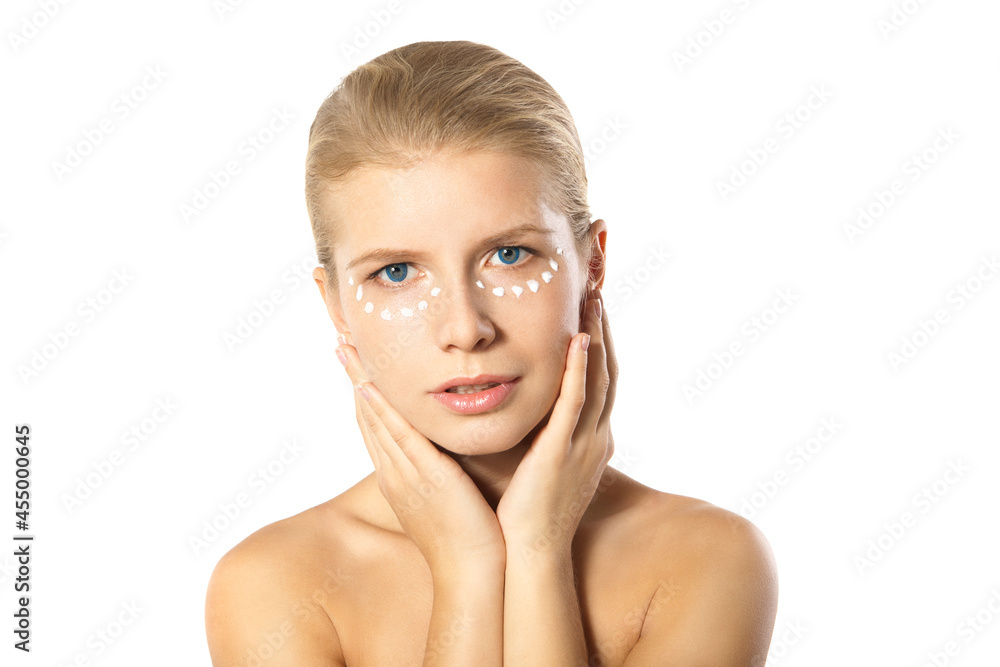 Fototapeta premium Woman applying moisturizer cream on face isolated