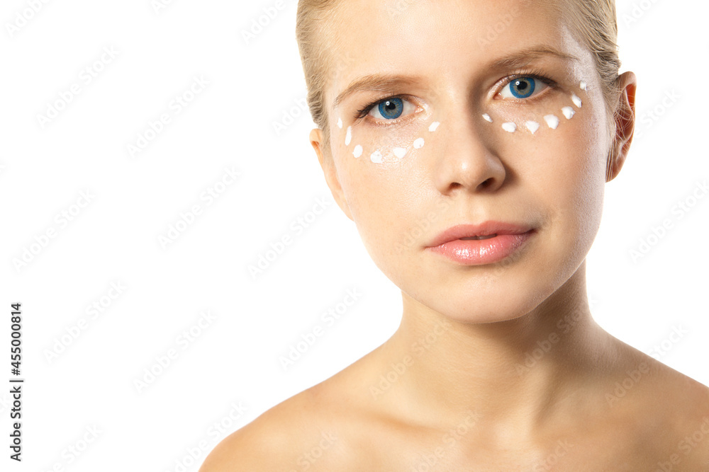 Fototapeta premium Woman applying moisturizer cream on face isolated