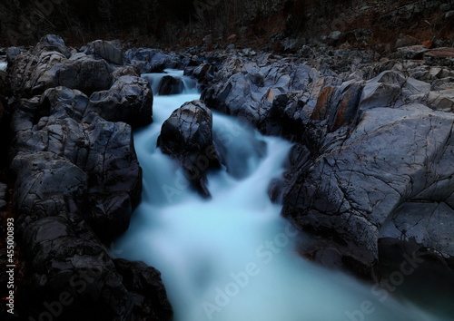 River cascade around large granite boulder