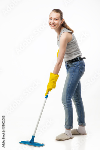 beautiful young woman cleaning floor with mop