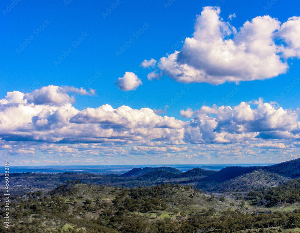 Scenic view with green hills and blue sky with white fluffy clouds in the high country, Burnett Region, Queensland, Australia. 1.