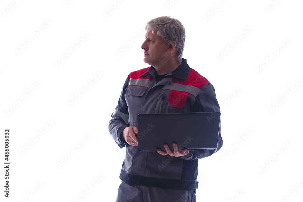 Gray-haired computer technician on white background. He will set up laptop while standing. computer technician in gray uniform. Experienced computer technician working. System administrator portrait Gray-haired computer technician on white background. He will set up laptop while standing. computer technician in gray uniform. Experienced computer technician working. System administrator portrait