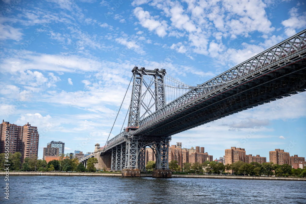 The Williamsburg Bridge is a suspension bridge in New York City across the East River connecting the Lower East Side of Manhattan at Delancey Street with the Williamsburg neighborhood of Brooklyn. The Williamsburg Bridge is a suspension bridge in New York City across the East River connecting the Lower East Side of Manhattan at Delancey Street with the Williamsburg neighborhood of Brooklyn.
