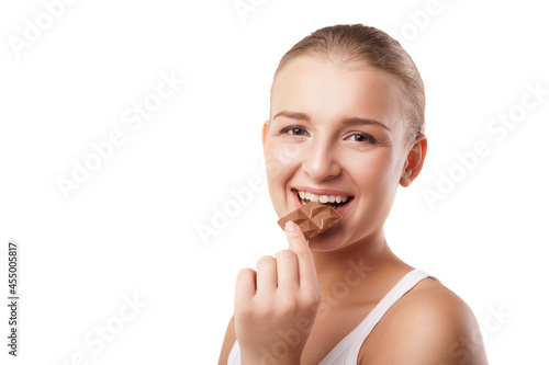 Blonde young woman biting chocolate isolated